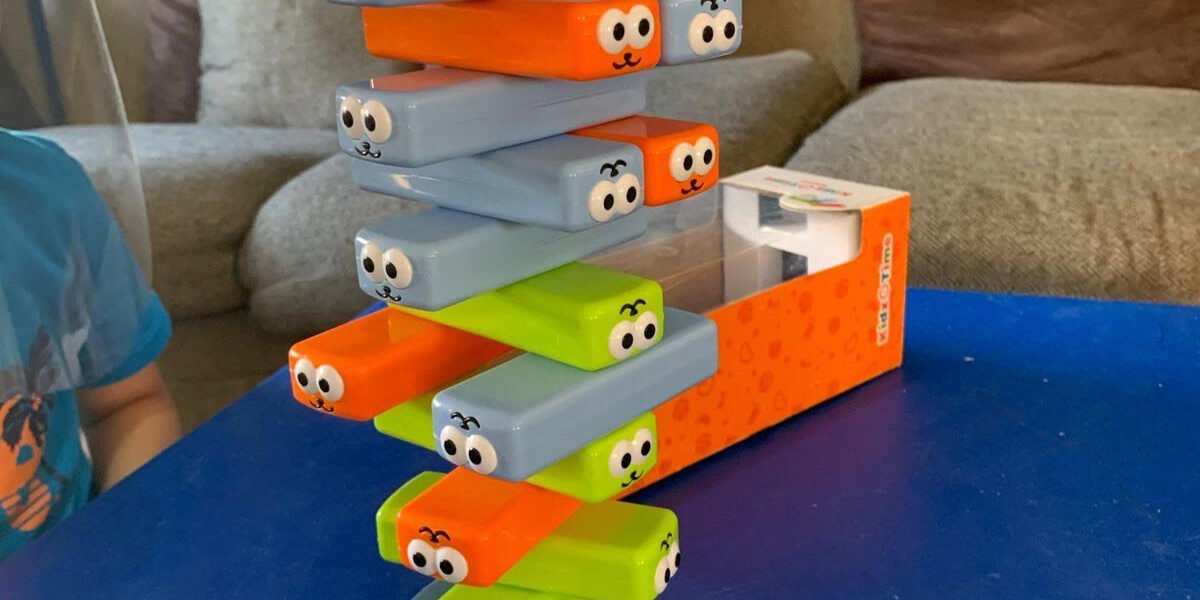 Torre de bloques apilables con caritas de colores, juego usado en actividades de estimulación
