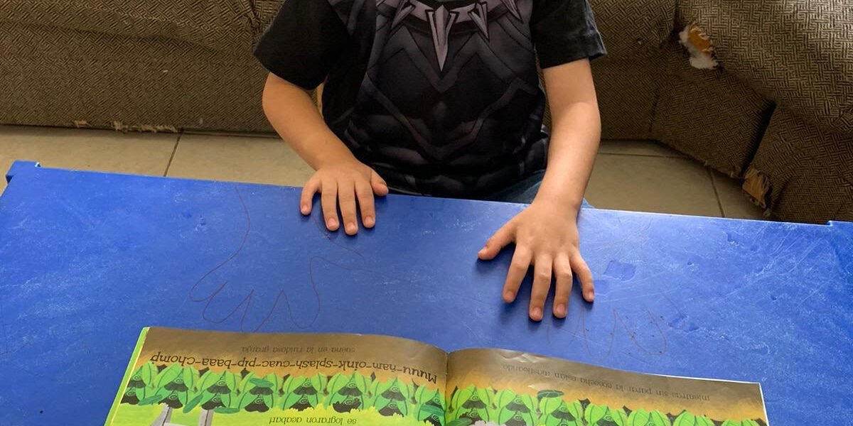 Niño sentado frente a un cuento ilustrado durante una actividad de lectura