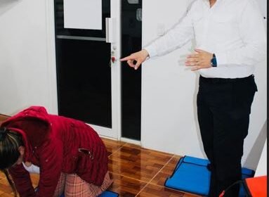 Instructor de primeros auxilios enseñando reanimación cardiopulmonar (RCP) a una terapeuta de Centro LUA con un maniquí de práctica
