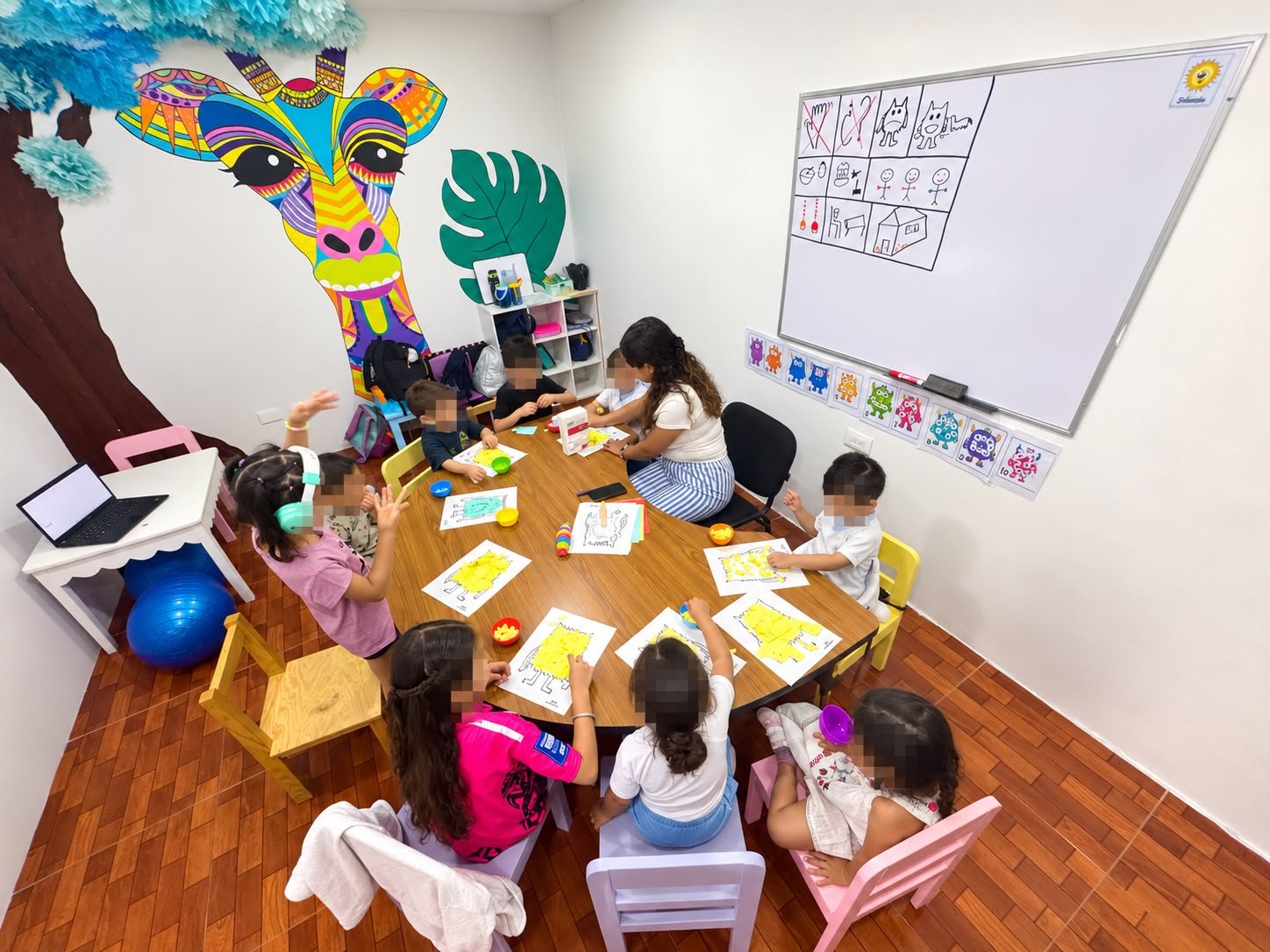 Grupo de niños en el programa Pre-Kínder de Centro LUA, sentados en mesa haciendo actividades con su terapeuta